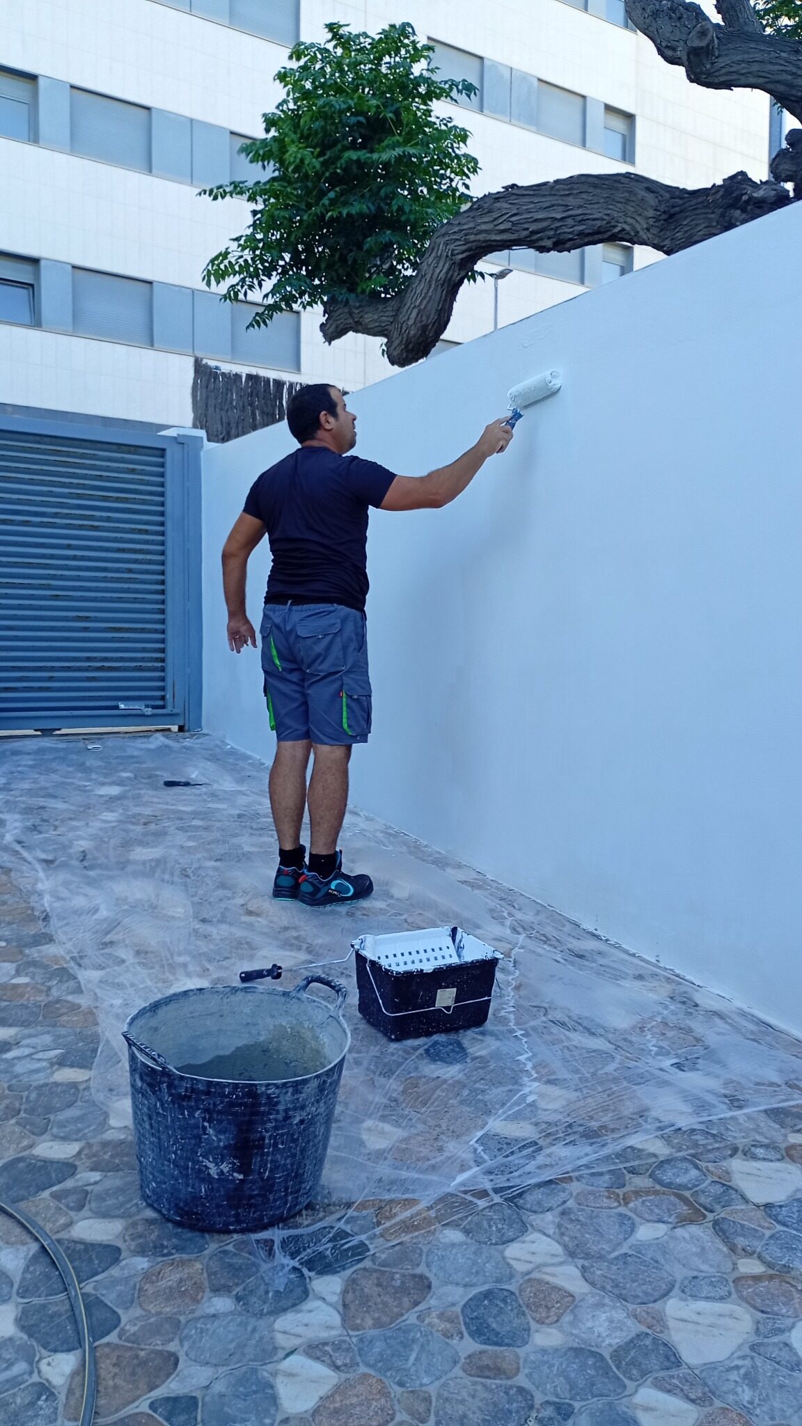 Eddy Ramírez aplicando pintura durante el acabado del muro exterior