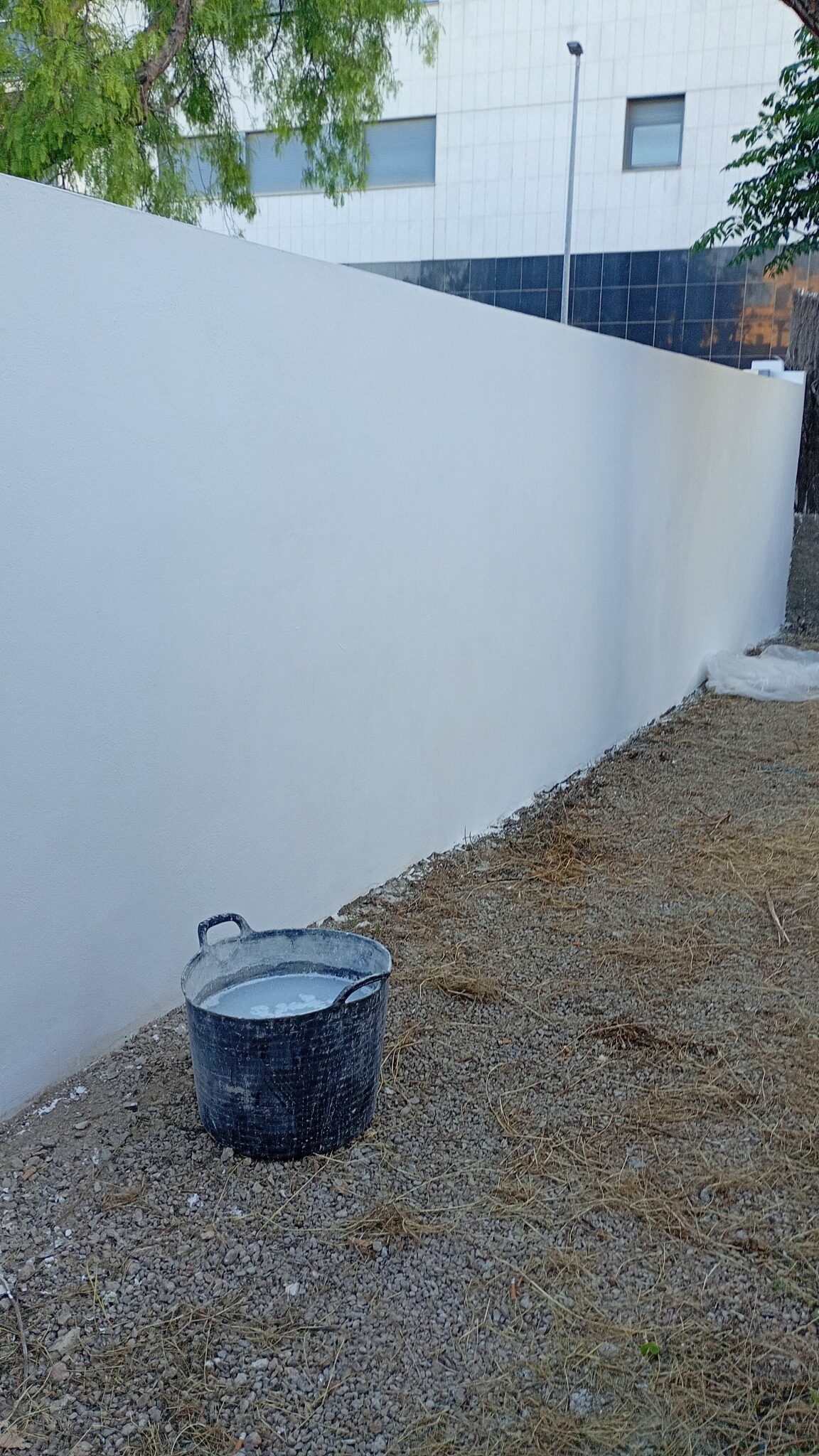 Resultado final del muro exterior terminado y pintado de blanco